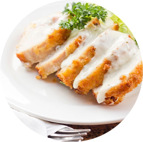 sliced chicken with white cause on top 